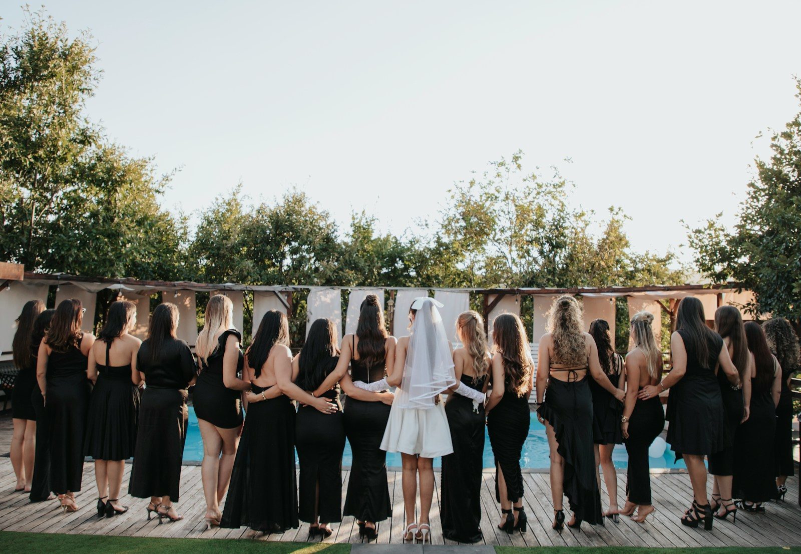 Group of women in black dresses by the pool