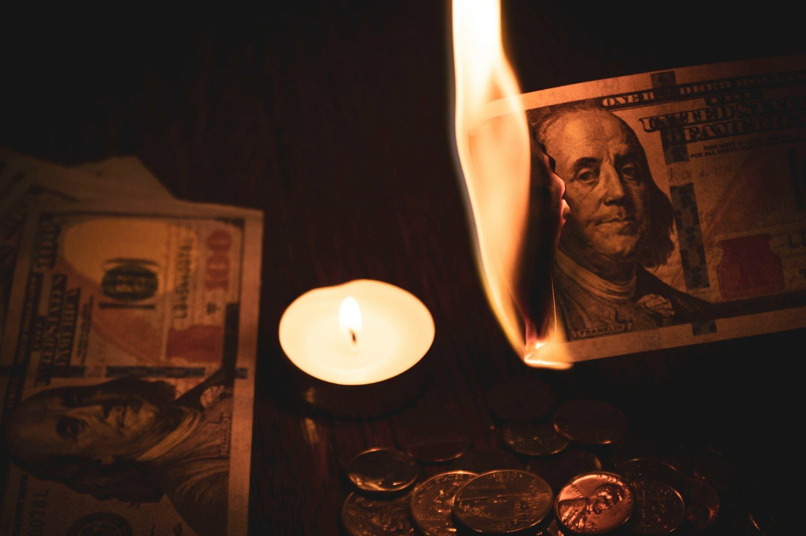 white pillar candle beside 100 us dollar bill